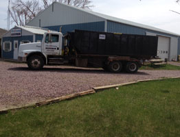 Commercial truck with roll-off bin.